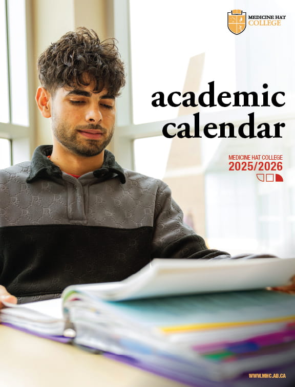 2025-2026 Academic Calendar cover. Male student sitting at table with books.