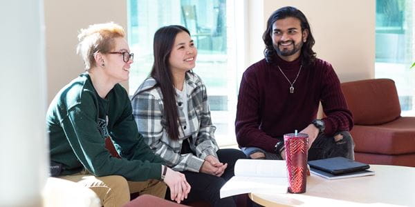 Three students sitting in the Centennial Hall. 