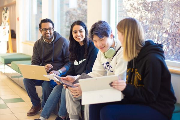 Students studying on bench. 