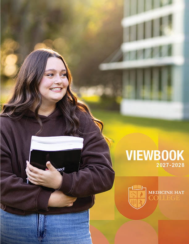 Female student smiling with books in hand, looking hopeful and excited. MHC viewbook cover 2027/28