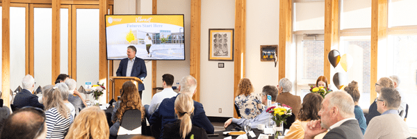 Large group of people watching a presentation by a presenter at an event