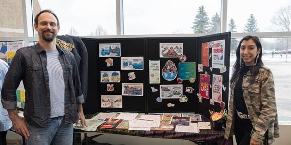 Sustainable Innovation students, Maria Solorzano and David Page standing beside their poster presentation.
