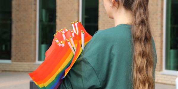 Close up of student holding pride flags