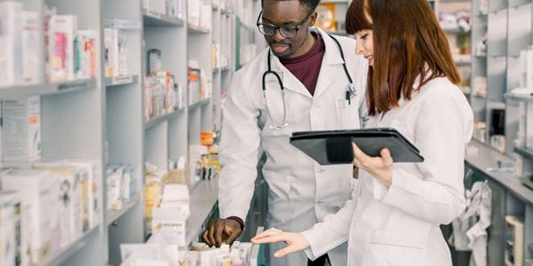 Two pharmacy technicians look at medications 